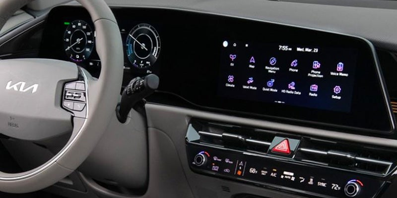 Dashboard of a modern car showing the steering wheel, digital instrument cluster, and main infotainment screen.