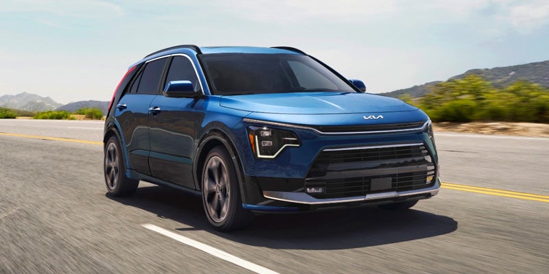 Blue Kia SUV driving on an open highway showcasing modern design and performance