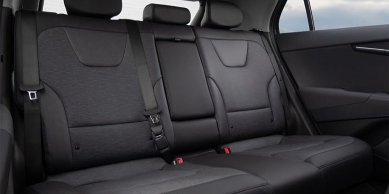 Rear seat view of car with black upholstery and seatbelts