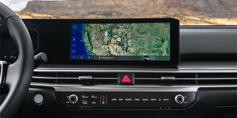 In-car navigation screen displays a detailed topographic map of the Southwestern United States, with dashboard controls below.