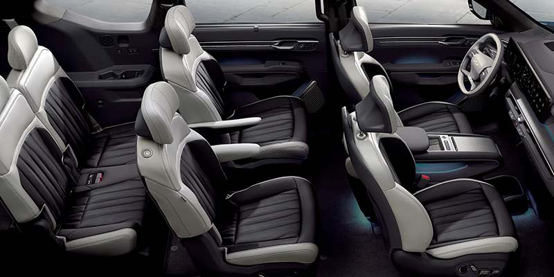 The interior of a modern car showcases reclining back seats and a sleek dashboard with a steering wheel.