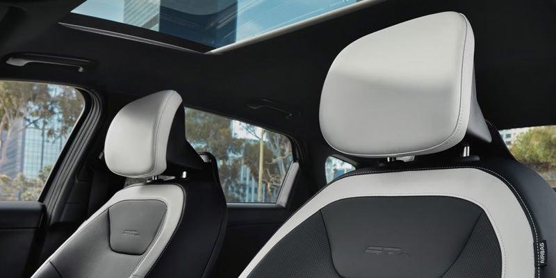 Kia K4 sedan front seats with dual-tone upholstery and panoramic sunroof