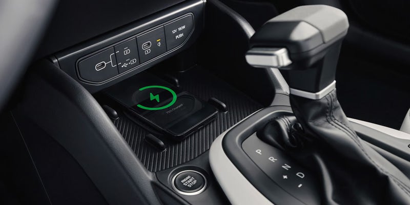 Kia K4 sedan center console with wireless charging pad and gear selector