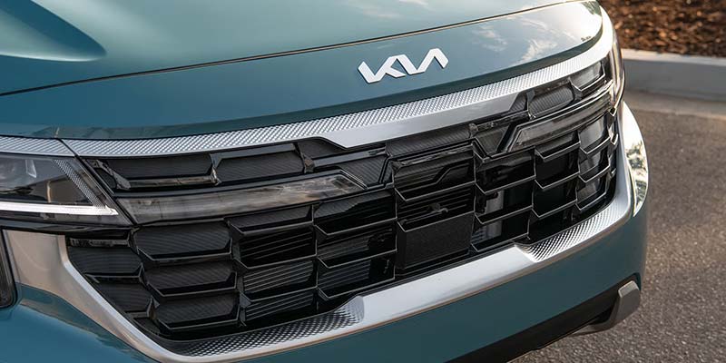 Close-up of Kia vehicle front grille with black geometric pattern