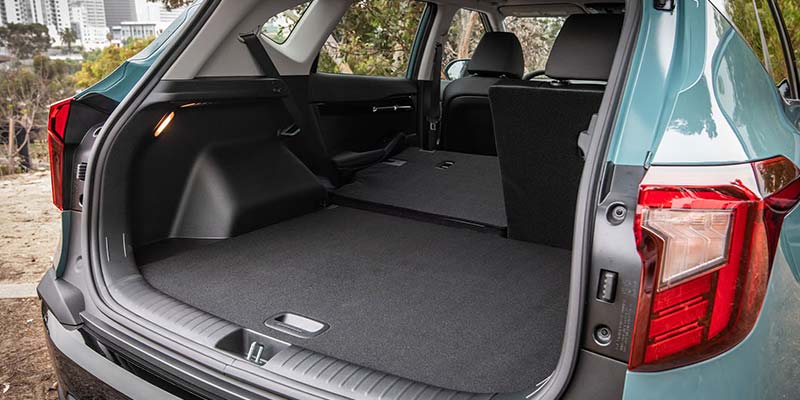 Rear view of a SUV with its trunk open, showing the rear seats folded flat.