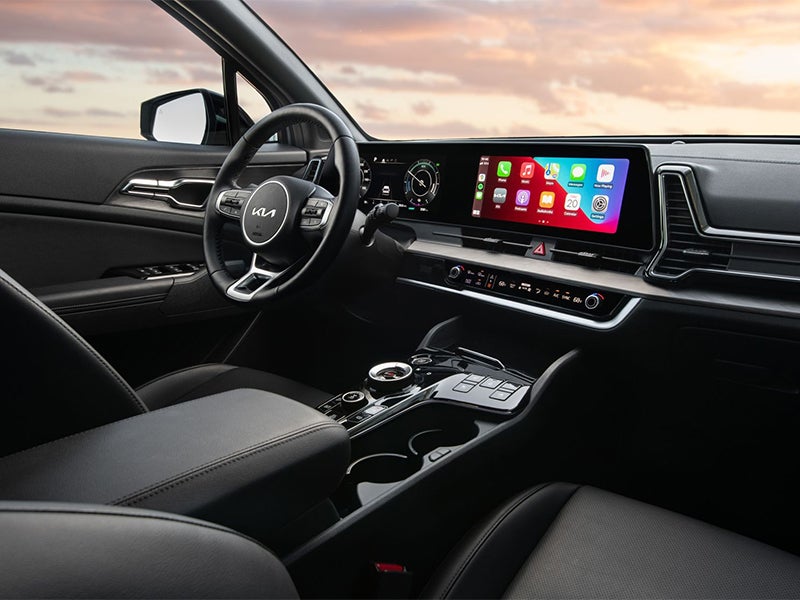 Interior of a modern car showing the dashboard, touchscreen display, steering wheel, and front passenger seat.
